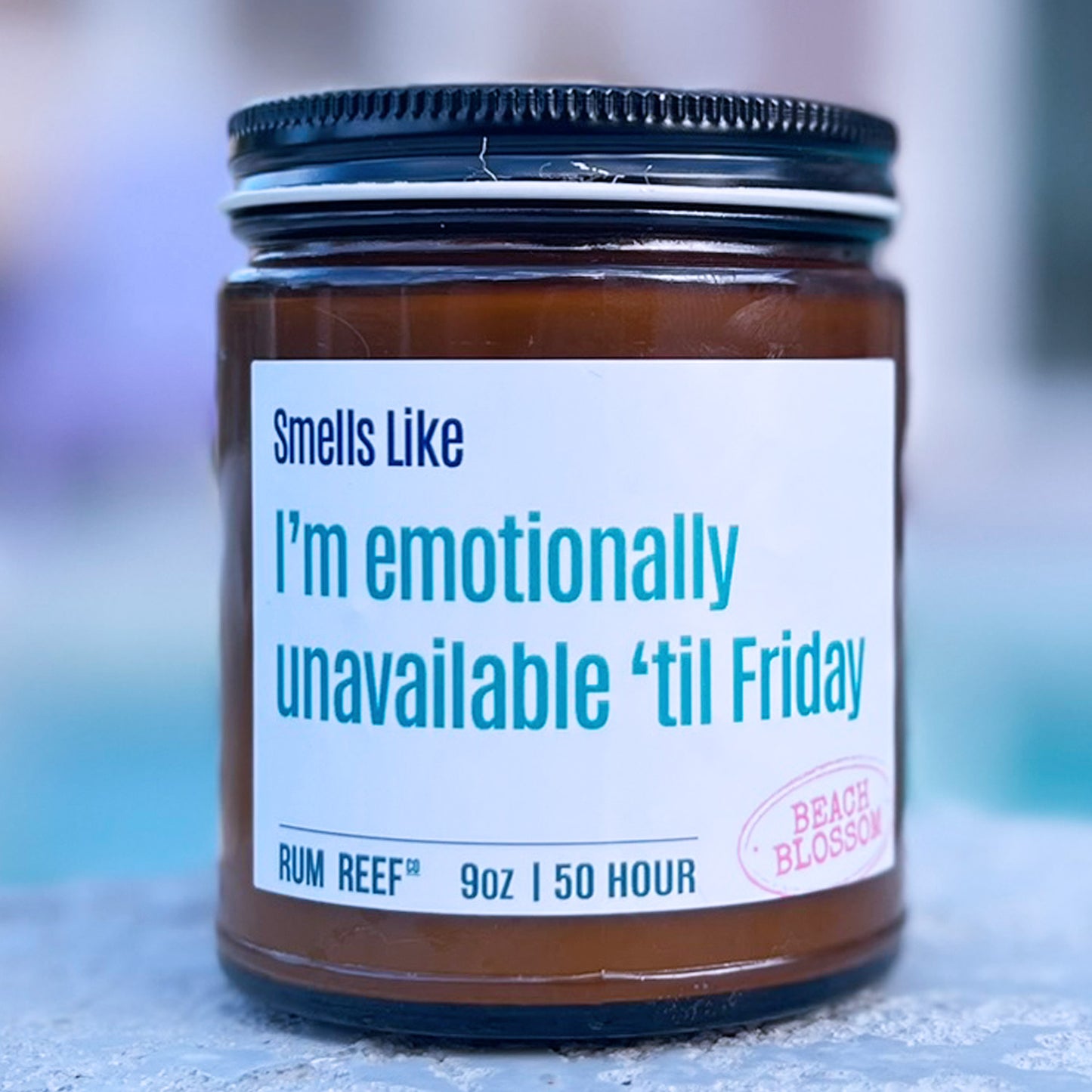 Candle jar with a humorous label on a blurred background