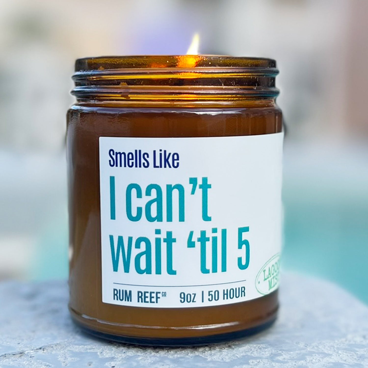 Candle in an amber jar with a humorous label on a blurred background